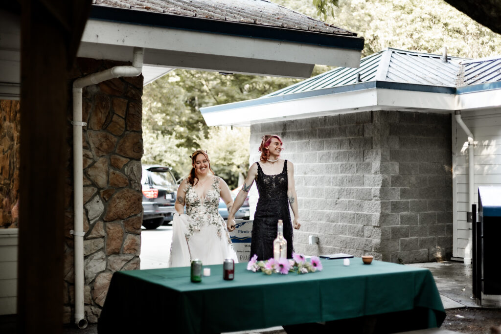 The brides enter their reception at their forest elopement in Langley