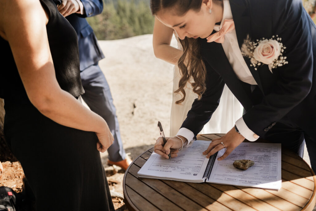 Melissa signs the marriage papers at this Sea to Sky Gondola wedding