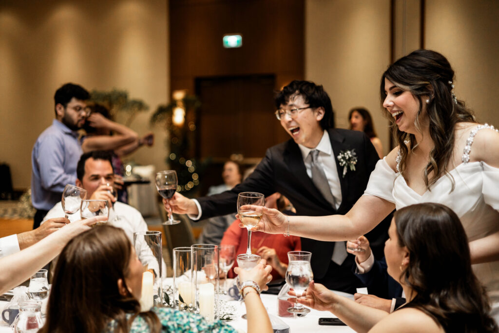 The bride and groom cheers with their guests during the reception at this downtown Vancouver Marriott Pinnacle wedding