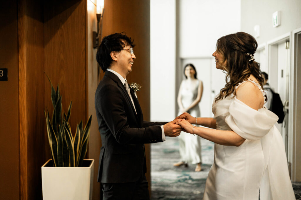 The bride and groom have a first look in front of the elevators at this downtown Vancouver Marriott Pinnacle wedding