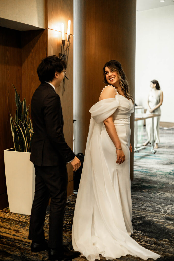 The bride turns around to show her dress off to the groom at this downtown Vancouver Marriott Pinnacle wedding