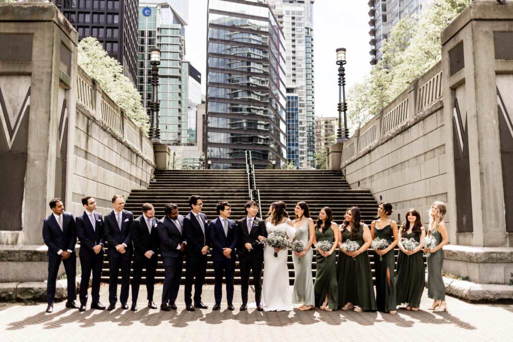 The bridal party posing in front of a staircase at this downtown Vancouver Marriott Pinnacle wedding