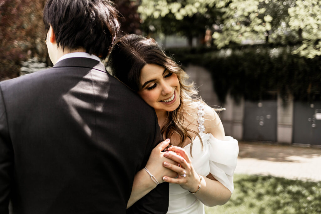 The bride rests her head on the grooms shoulder at this downtown Vancouver Marriott Pinnacle wedding