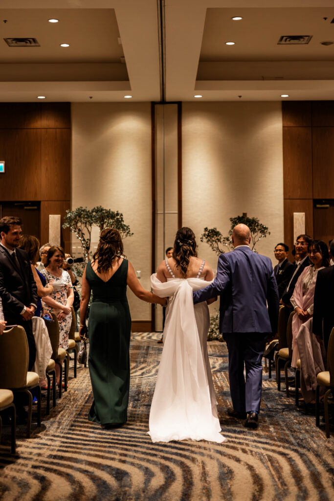 The brides parents walk her down the aisle at this downtown Vancouver Marriott Pinnacle wedding