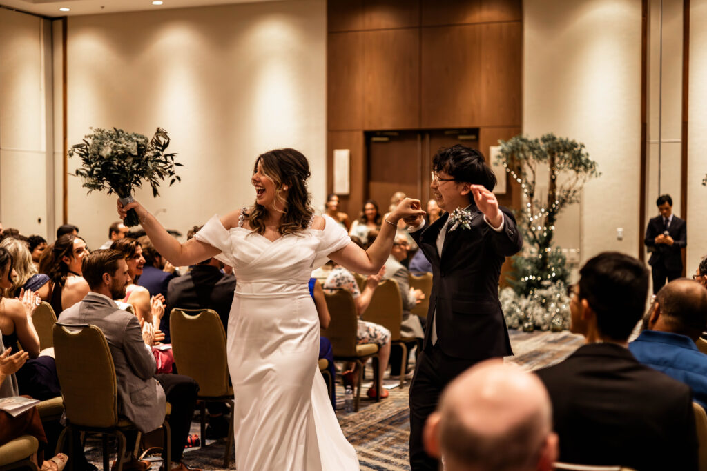 The bride and groom dance back down the aisle of their downtown Vancouver Marriott Pinnacle wedding