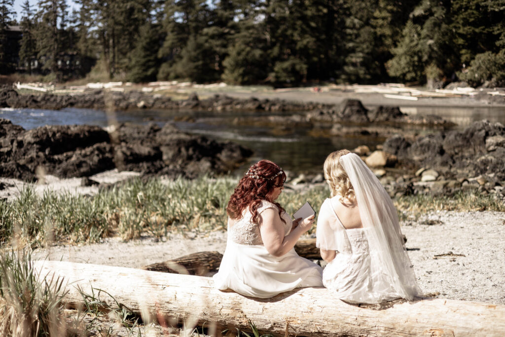 A shot from behind of the brides sharing their vows on the beach at their Black Rock Oceanfront Resort wedding.