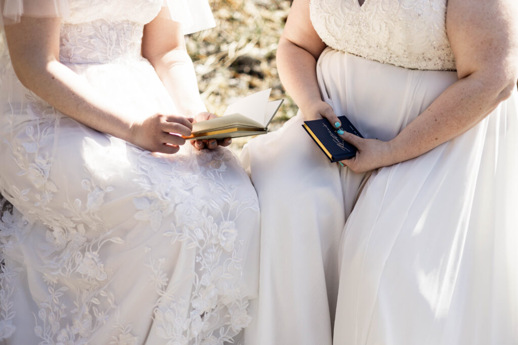 An upclose of the brides hands holding their vow books at their Black Rock Oceanfront Resort wedding.