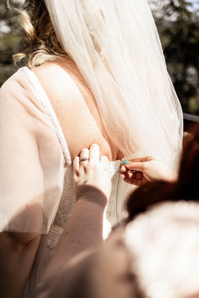 Zipping up a bride's dress at a Black Rock Oceanfront Resort wedding.