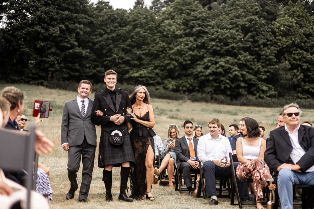 Groom is walked down the aisle by his parents at this Church and State Winery wedding