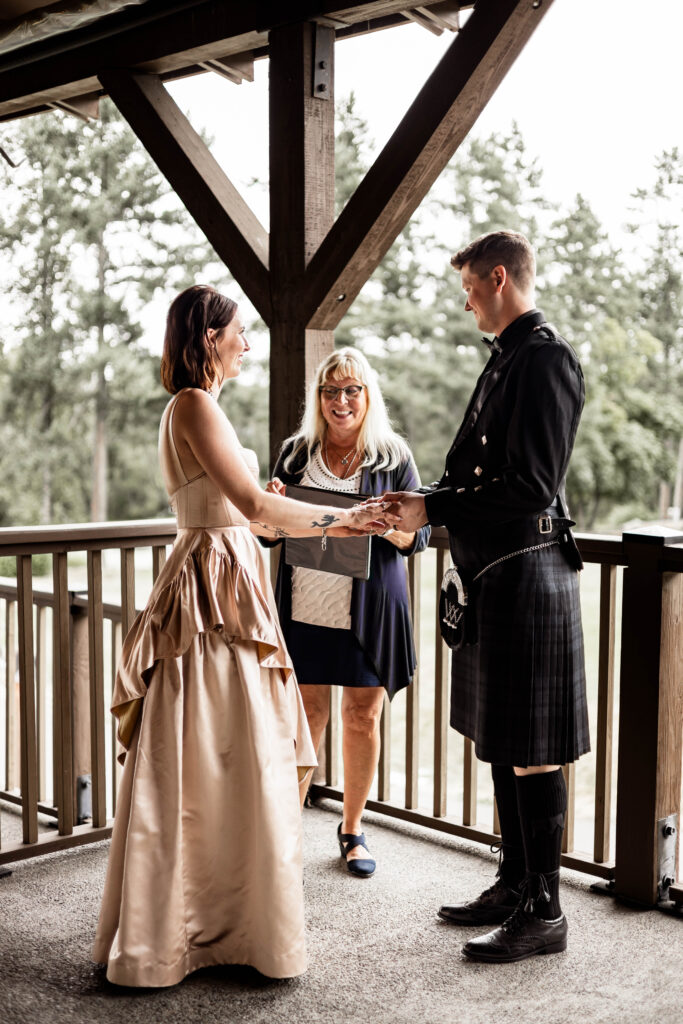 Bride and groom hold hands in front of their officiant at this Church and State Winery wedding