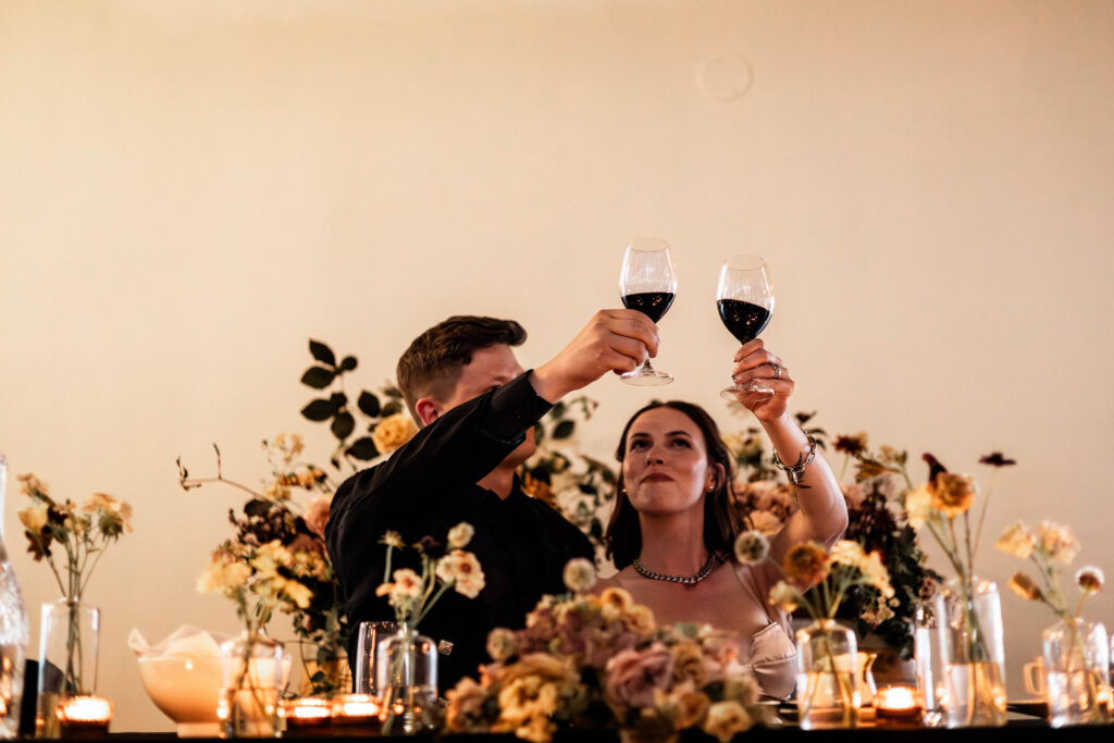 Bride and groom cheers their glasses during speeches at this Church and State Winery wedding