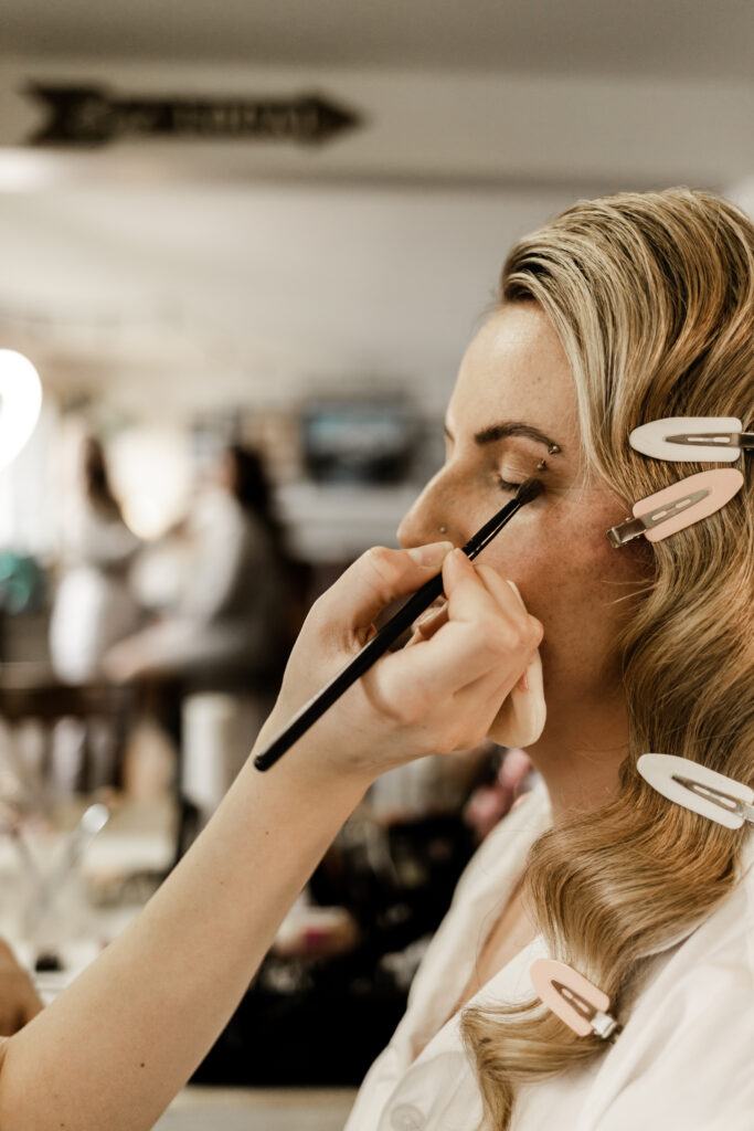 The bride gets her makeup done at this Canim Lake wedding