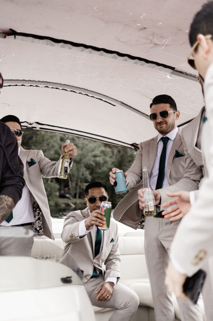 The groomsmen cheers on the boat at this canim lake wedding