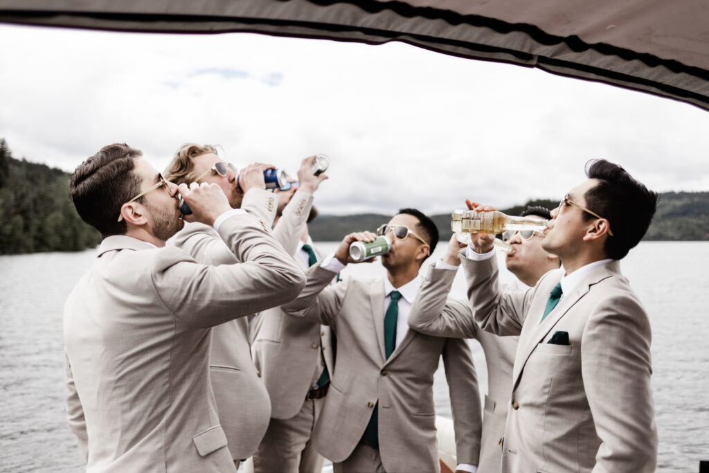 The groomsmen sip their drinks on the boat at this canim lake wedding