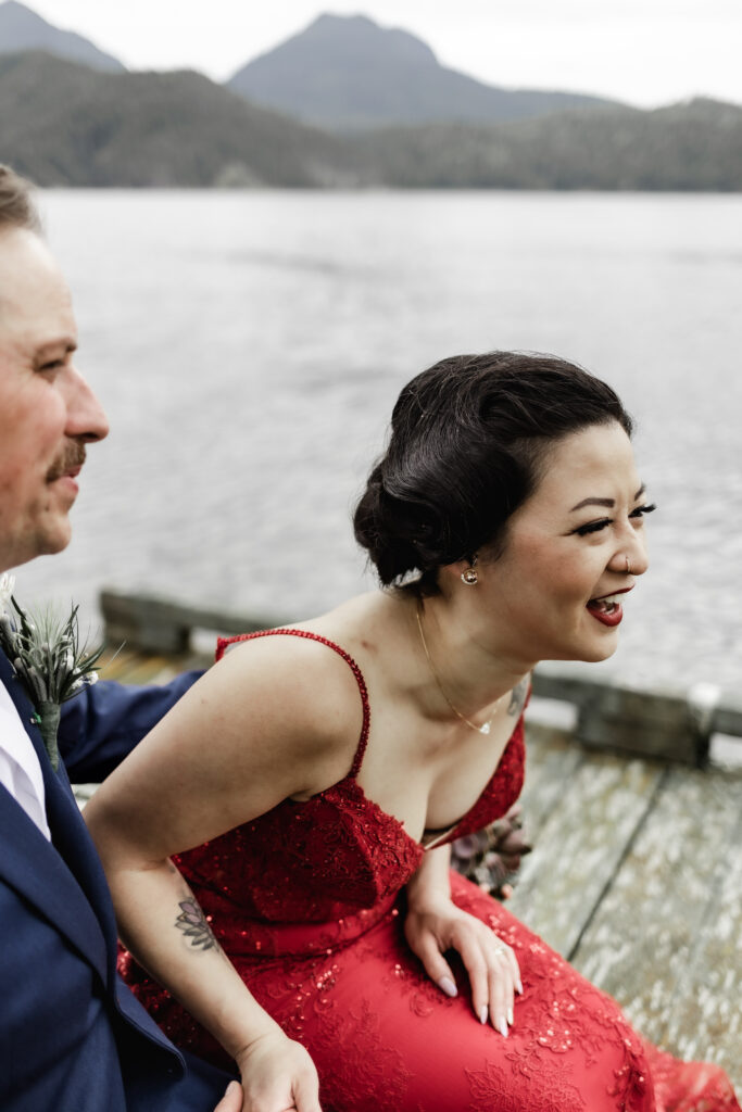 The bride leans forward in laughter at her Gibsons Island summer camp wedding at Camp Elphinstone