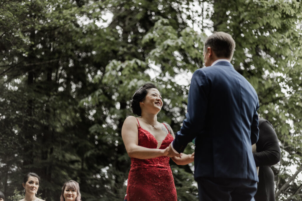 The bride laughs during the ceremony at this Gibsons Island summer camp wedding at Camp Elphinstone