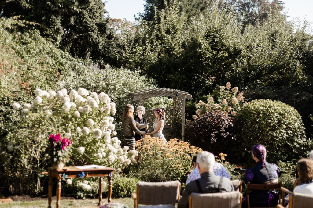 A faraway shot of the bride and groom holding hands at the altar at this Vancouver Island costume wedding