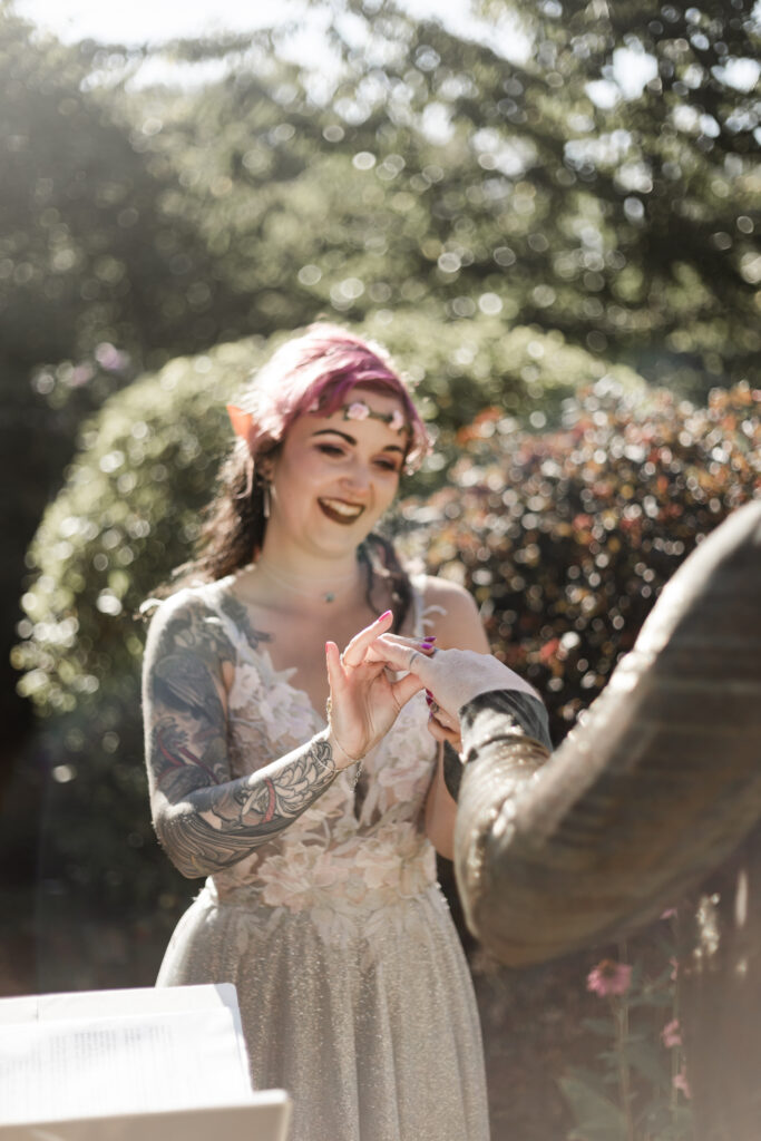 The bride places the ring on the grooms finger at this Vancouver Island costume wedding