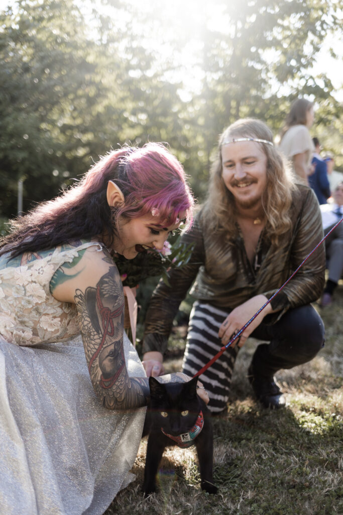 The bride and groom pose with their black cat at this Vancouver Island costume wedding