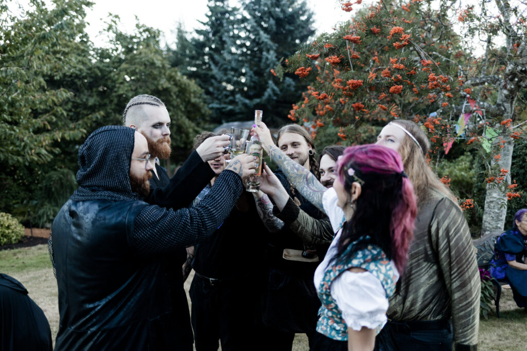 Bride, groom, and close friends cheers before taking a shot at this Vancouver Island costume wedding