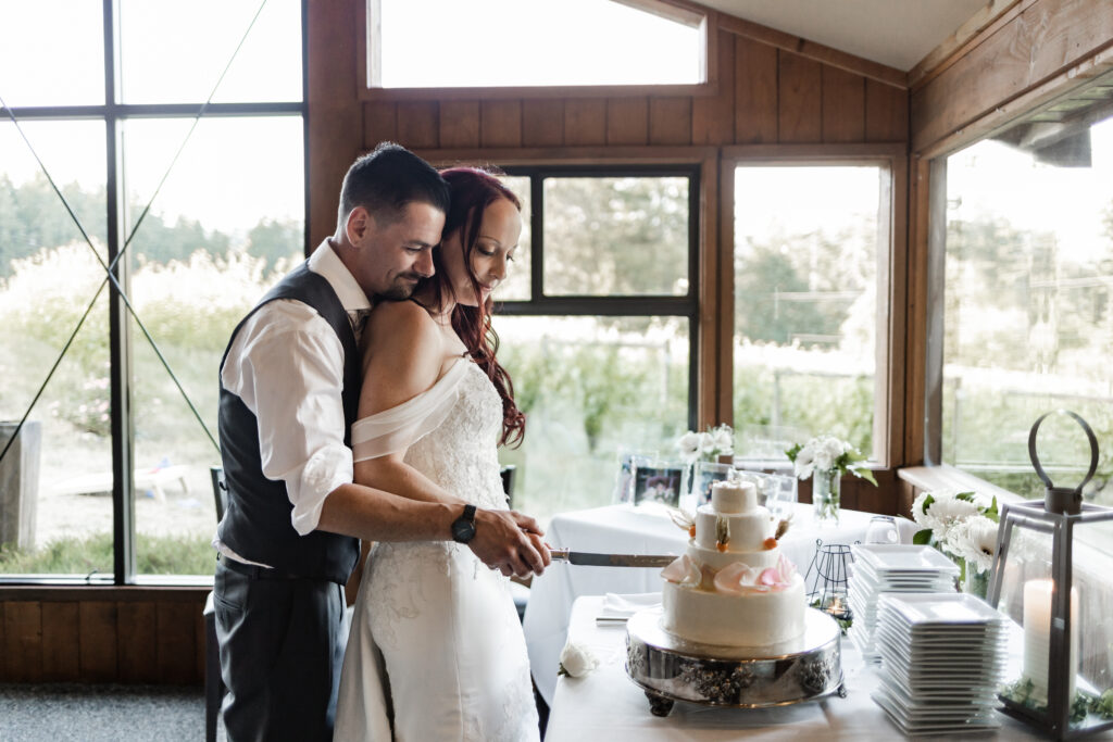 bride and groom cut the cake at this Cobble Hill Winery wedding