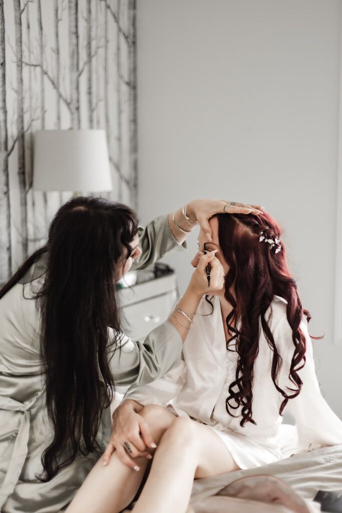 bride getting makeup done at this Cobble Hill Winery wedding