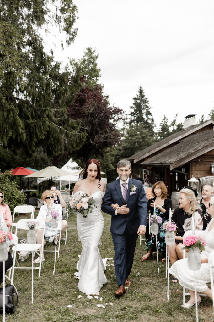 bride walks down the aisle with her father at this Cobble Hill Winery wedding