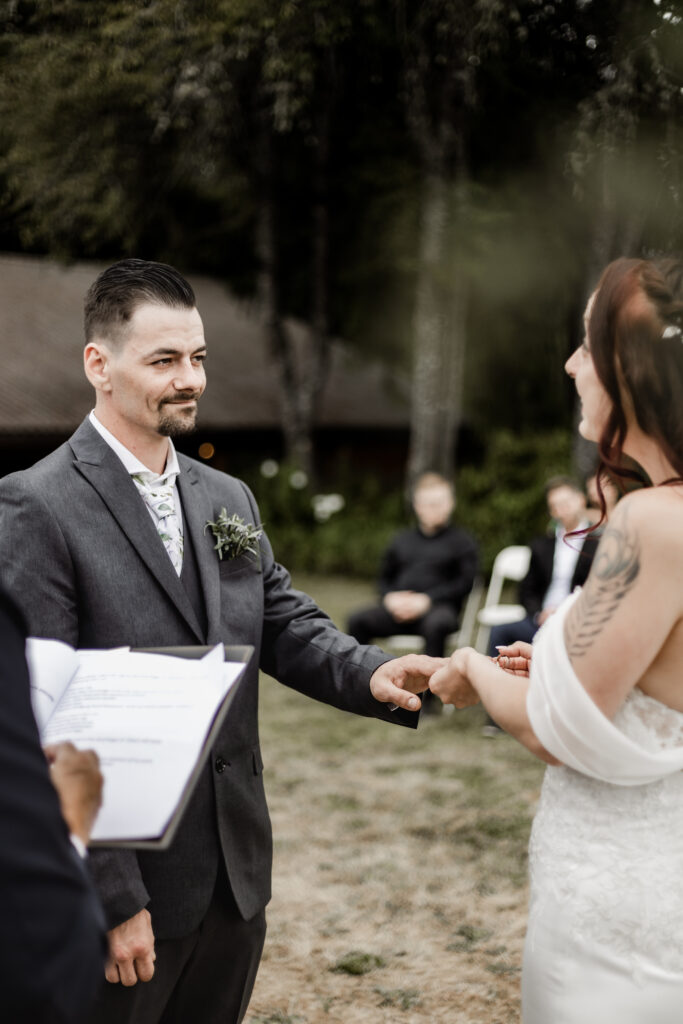 the couple exchange rings at the ceremony at this Cobble Hill Winery wedding