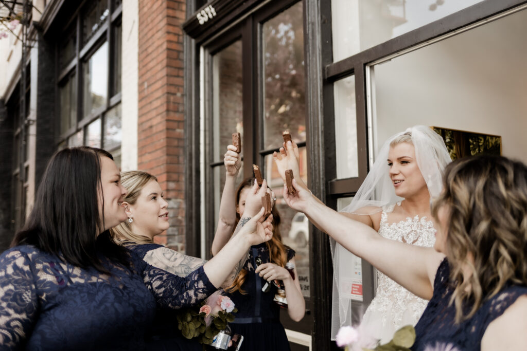 bride and her bridesmaids cheers with chocolate bars at this downtown Victoria wedding