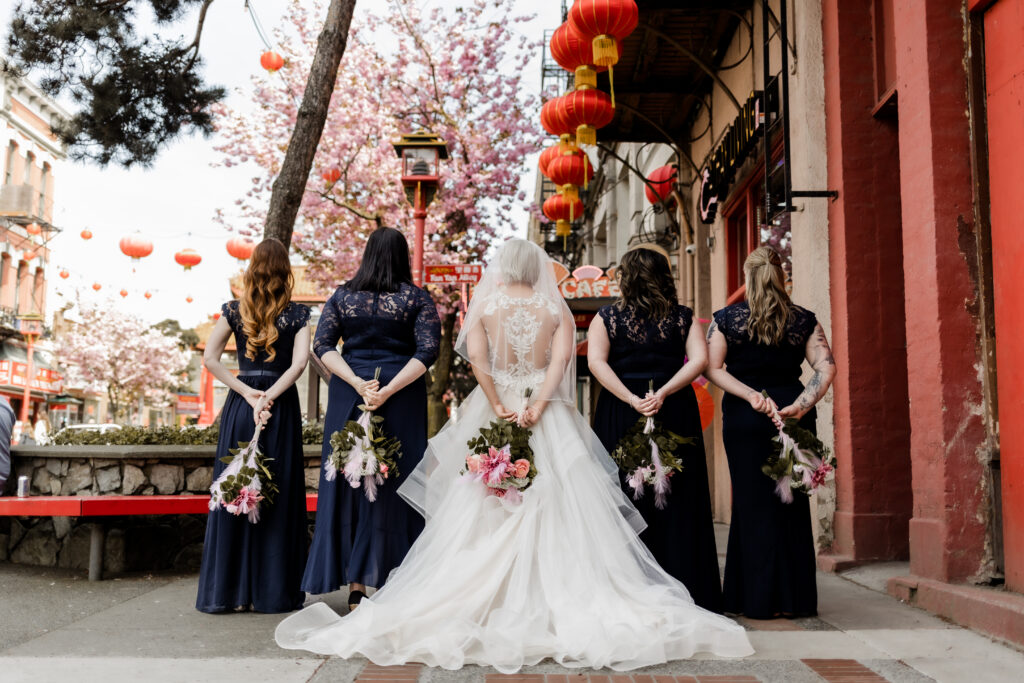 bride and bridesmaids pose outside of Fortune Gallery at this downtown Victoria wedding