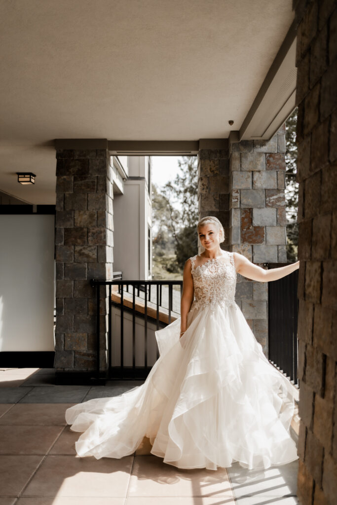 Bride poses on the balcony of her hotel room at this downtown Victoria wedding