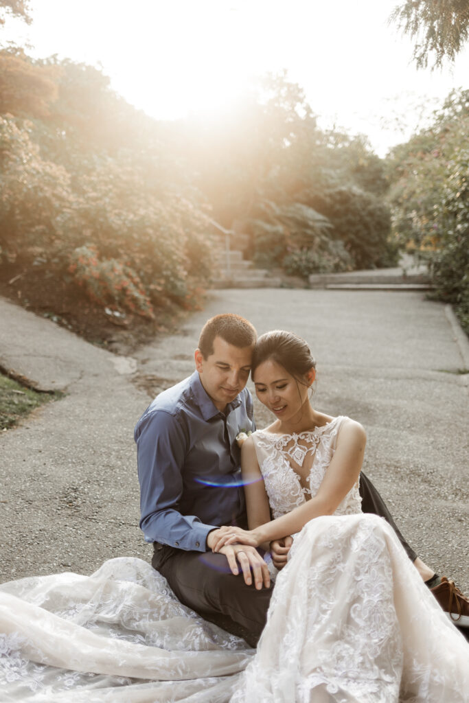 The couple admire their wedding rings as the sun streams in from behind at this Bloedel Conservatory wedding 