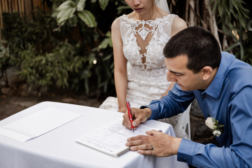 The groom signs the marriage papers at this Bloedel Conservatory wedding 