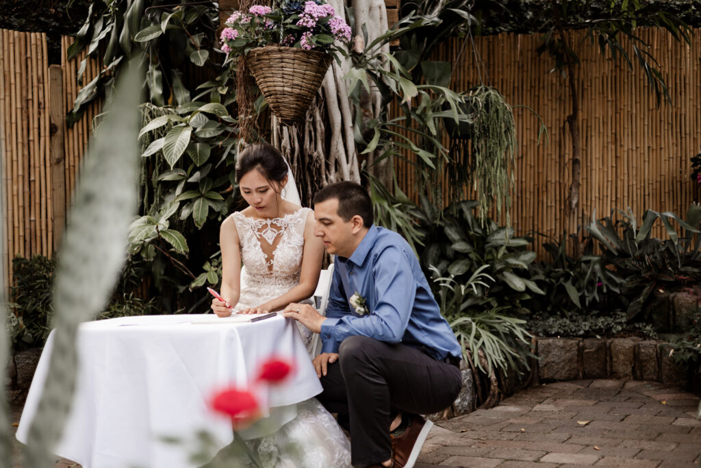 The bride signs the marriage papers at this Bloedel Conservatory wedding 