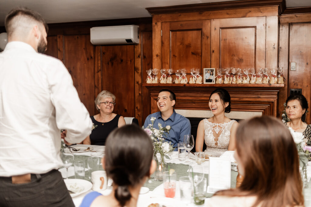 The couple laugh during speeches at this Bloedel Conservatory wedding 