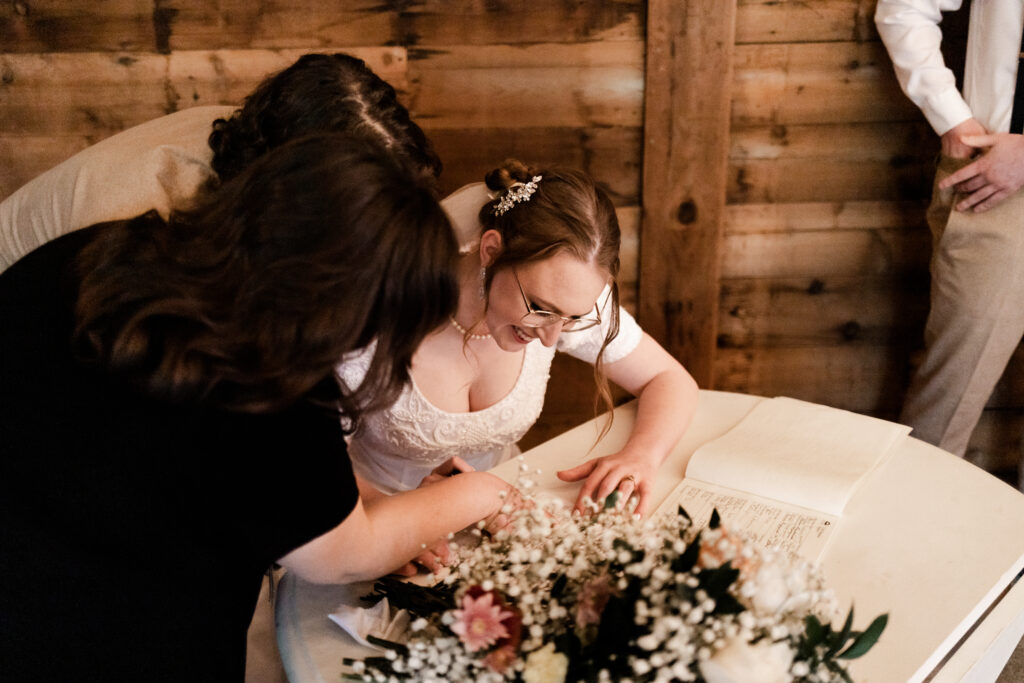 The bride signs the marriage papers at this Estate 248 wedding in Langley, British Columbia