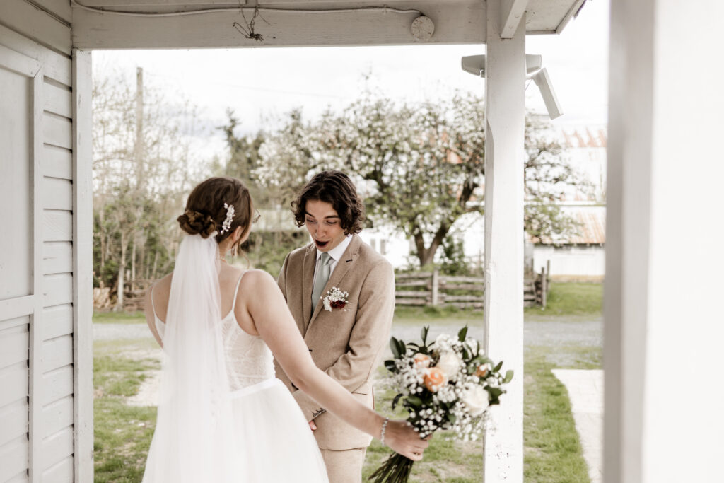 The groom reacts in shock seeing the bride in her wedding dress at this Estate 248 wedding in Langley, British Columbia