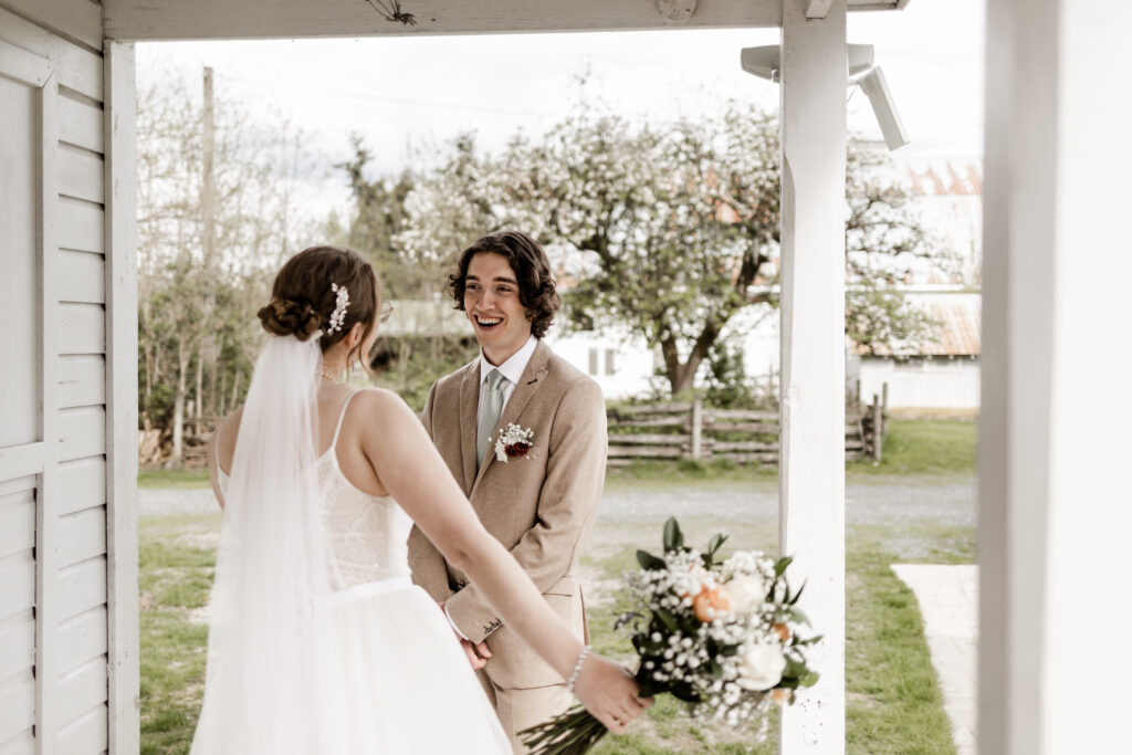 The groom reacts in shock seeing the bride in her wedding dress at this Estate 248 wedding in Langley, British Columbia