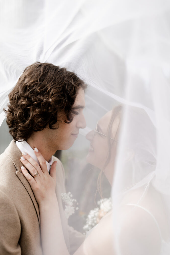 Bride and groom stand nose to nose underneath the bride's veil at this Estate 248 wedding in Langley, British Columbia