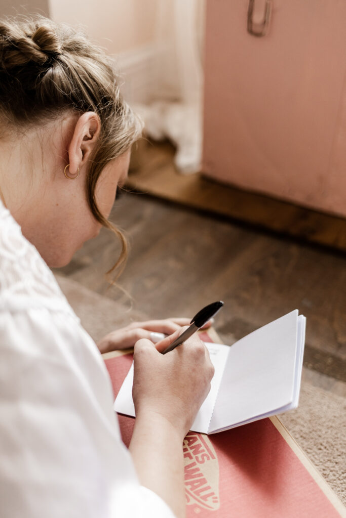 The bride writing her vows in her vow book at this Estate 248 wedding in Langley, British Columbia