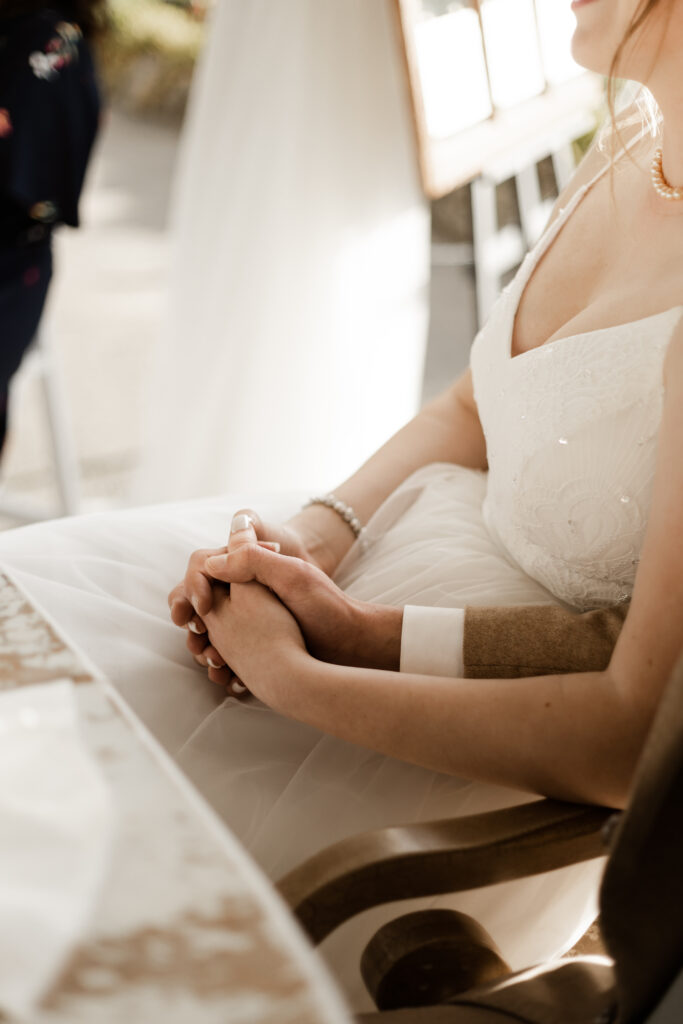 An up close of the bride and groom holding hands during speeches at their Estate 248 wedding in Langley, British Columbia