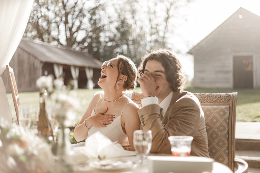 The bride and groom share a laugh during speeches at their Estate 248 wedding in Langley, British Columbia