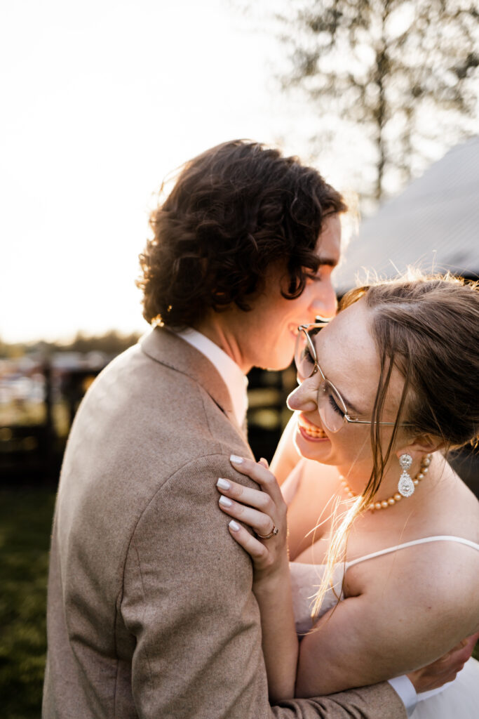 an up close of the bride and groom holding each other and laugh as the golden sun shines in from behind at this Estate 248 wedding in Langley, British Columbia