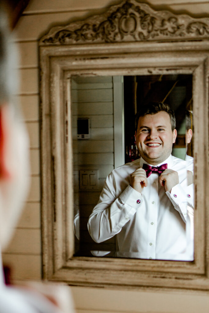 Groom adjusts tie at his Bird's Eye Cove wedding