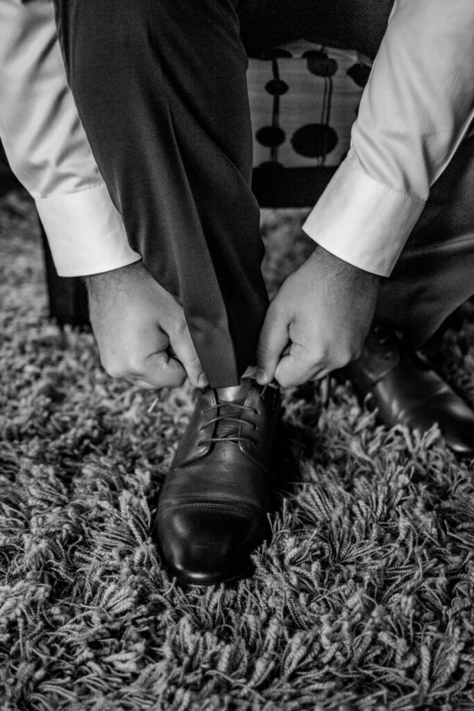 Groom puts on shoes at this Bird's Eye Cove wedding