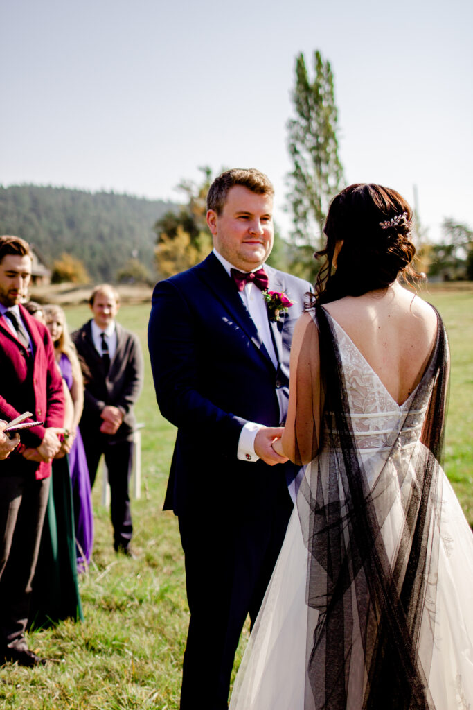 Bride and groom hold hands at the altar at this Bird's Eye Cove wedding