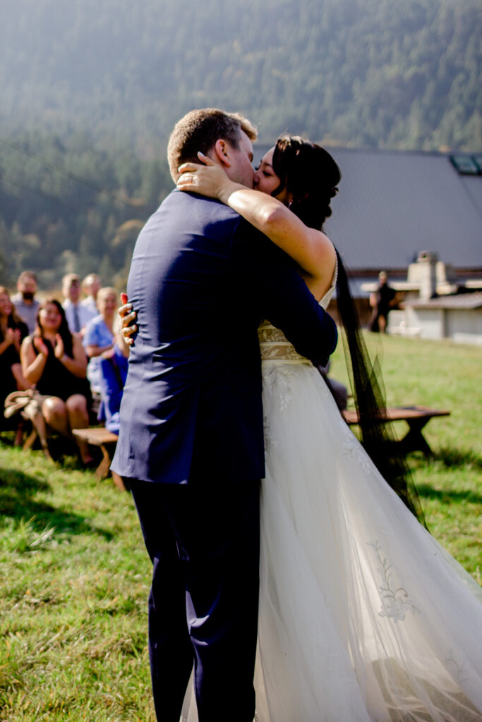 Bride and groom share a first kiss at the altar at this Bird's Eye Cove wedding