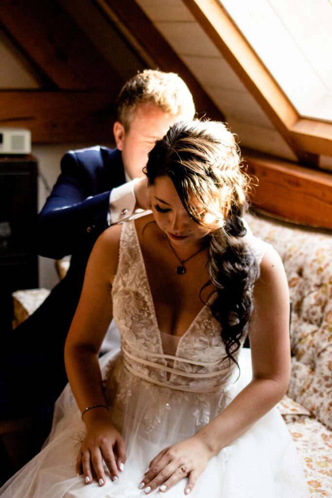 Groom puts necklace on bride at this Bird's Eye Cove wedding