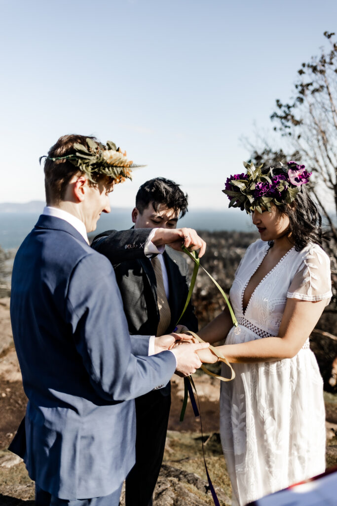 A bride and groom participate in a hand fasting ritual at a Mount Douglas Elopement.