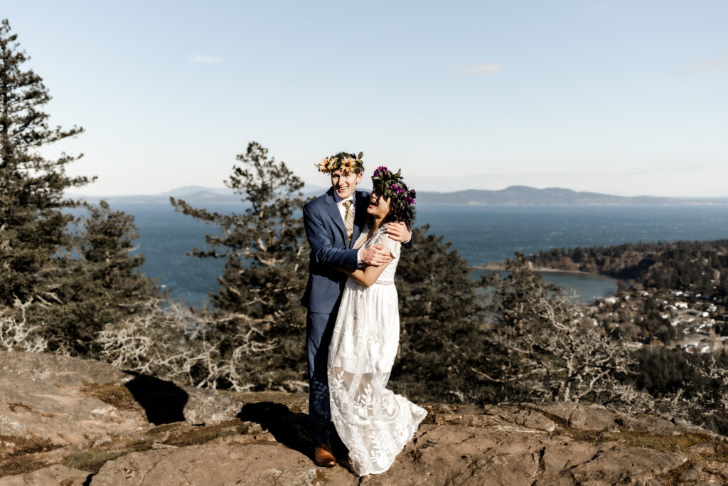 The newly wed couple share a laugh in front of the ocean view at their Mount Douglas elopement